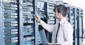 An IT technician looking at a bank of computer servers